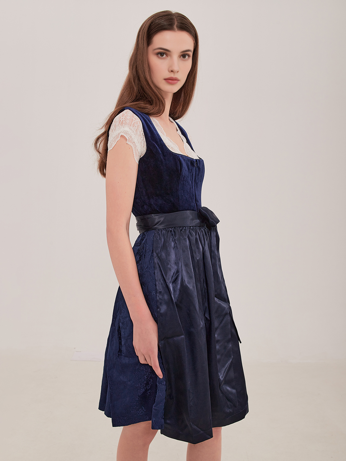 Ein elegantes dunkelblaues Dirndl mit weißer Spitzenbluse